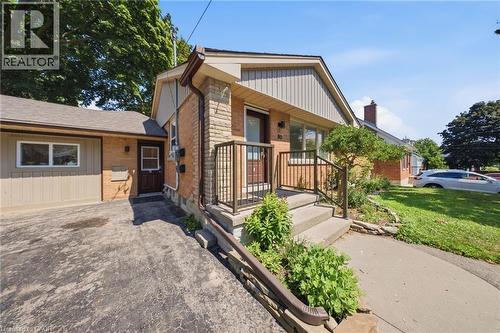 Brick and stone facade residence featuring a concrete driveway, established front landscaping, and a covered entry - 80 Jackson Avenue, Kitchener, ON - Outdoor