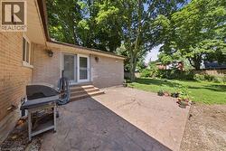 Expansive stamped concrete patio with multiple steps leading to a sliding glass door entry - 