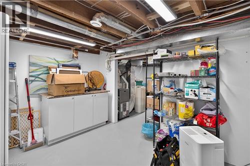 Utility room featuring exposed ceiling joists, overhead strip lighting, white cabinetry with a countertop, and painted concrete flooring - 9 Davidson Street, Cambridge, ON - Indoor Photo Showing Basement