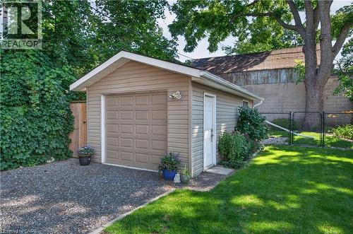 Detached garage with tan siding, a panel-style garage door, and a side access door - 9 Davidson Street, Cambridge, ON - Outdoor