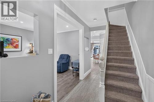Entryway featuring a carpeted staircase with white balusters, wood-finish flooring, and a wall cutout opening to an adjacent room - 9 Davidson Street, Cambridge, ON - Indoor Photo Showing Other Room