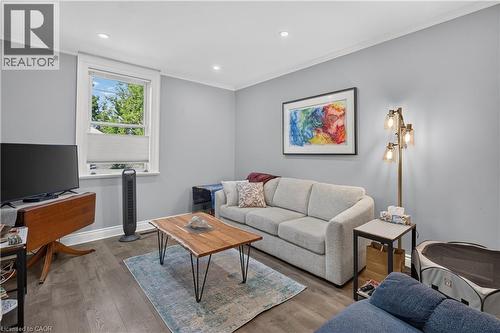 Spacious living area featuring wood-finish flooring, recessed lighting, a large window, and contemporary wall color - 9 Davidson Street, Cambridge, ON - Indoor Photo Showing Living Room