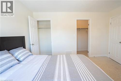 Bedroom featuring light-toned walls, textured carpet flooring, and white trim - 44 Medici Lane, Hamilton, ON - Indoor Photo Showing Bedroom