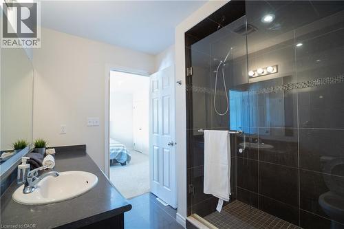 Contemporary bathroom featuring a glass-enclosed shower with dark tile surround and decorative mosaic accent - 44 Medici Lane, Hamilton, ON - Indoor Photo Showing Bathroom