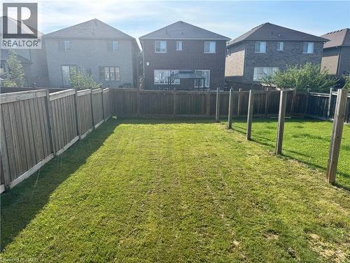 Expansive backyard featuring a large grass lawn and wood fencing - 44 Medici Lane, Hamilton, ON - Outdoor