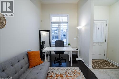 Bright room featuring a window with white blinds, dark wood-finish flooring, and a white paneled entry door - 44 Medici Lane, Hamilton, ON - Indoor Photo Showing Office