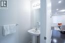 Pedestal sink with chrome faucet, wall-mounted mirror, overhead vanity lighting, and chrome towel bar - 44 Medici Lane, Hamilton, ON  - Indoor Photo Showing Bathroom 
