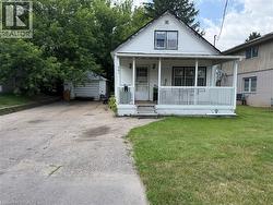 White siding exterior with a covered front porch featuring white railings - 