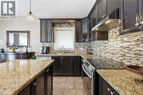 Kitchen featuring dark wood cabinetry, light speckled countertops, and a full-height mosaic tile backsplash - 1332 Baseline Road, Stoney Creek, ON - Indoor Photo Showing Kitchen With Double Sink With Upgraded Kitchen