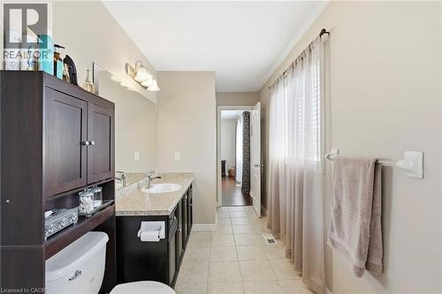 Spacious bathroom featuring an elongated vanity with an integrated sink, a large wall mirror, and a multi-bulb light fixture - 1332 Baseline Road, Stoney Creek, ON - Indoor Photo Showing Bathroom