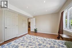 Spacious room featuring wood-finish flooring, recessed lighting, and a large window providing ample natural light - 