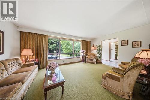 Spacious living area featuring expansive windows, green textile flooring, and white walls - 1598 Highway No 6, Hamilton, ON - Indoor Photo Showing Living Room