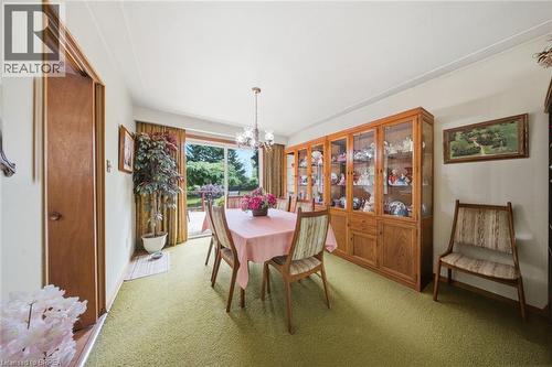 Dining area with a built-in wooden display cabinet featuring glass doors and lower storage - 1598 Highway No 6, Hamilton, ON - Indoor Photo Showing Dining Room