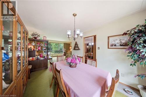 Dining area featuring a brass chandelier, wood-finish flooring, and light-toned walls - 1598 Highway No 6, Hamilton, ON - Indoor Photo Showing Dining Room