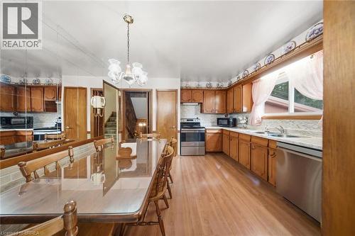Kitchen featuring wood-finish flooring, ample wood cabinetry, stainless steel appliances, and a double basin sink - 1598 Highway No 6, Hamilton, ON - Indoor Photo Showing Kitchen With Double Sink