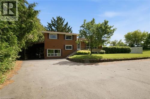Brick residence with a prominent asphalt driveway, mature trees, and established landscaping - 1598 Highway No 6, Hamilton, ON - Outdoor
