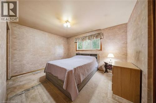 Bedroom featuring a window with exterior tree scenery, wood-frame window, and a flush-mount ceiling light fixture - 1598 Highway No 6, Hamilton, ON - Indoor Photo Showing Bedroom