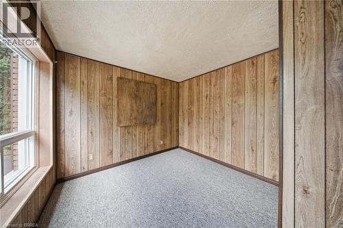 Room featuring paneled walls, light grey carpeting, and a large window with white framing - 1598 Highway No 6, Hamilton, ON - Indoor Photo Showing Other Room