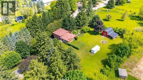 Expansive property featuring a red brick residence with a red roof, surrounded by mature evergreen trees - 1598 Highway No 6, Hamilton, ON - Outdoor With View