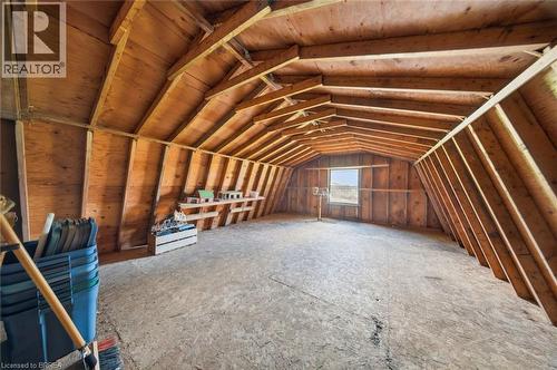 Spacious unfinished attic space featuring exposed wood framing, plywood walls, and a single window - 1598 Highway No 6, Hamilton, ON - Indoor Photo Showing Other Room