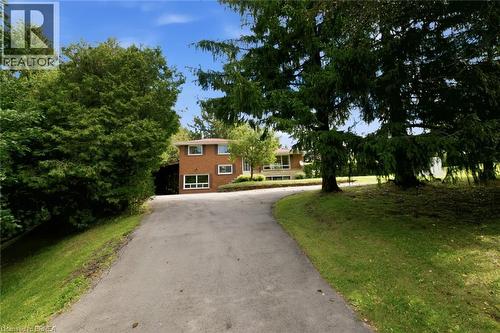 Brick exterior residence with multiple windows, a sloped asphalt driveway, and mature landscaping - 1598 Highway No 6, Hamilton, ON - Outdoor