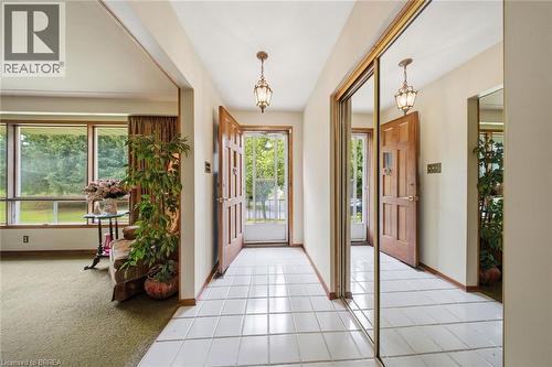 Entryway featuring white square tile flooring and two prominent paneled wood doors - 1598 Highway No 6, Hamilton, ON - Indoor Photo Showing Other Room