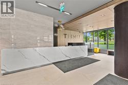 Modern reception area featuring a white stone-finish reception desk with gray veining, a large-format grey tile accent wall, wood-finish ceiling panels, and full-height windows - 