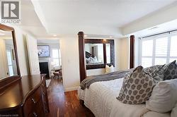 Bedroom featuring wood-finish flooring, recessed lighting, and white plantation shutters - 