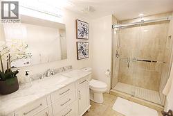 Full bathroom featuring a white vanity with a marble-finish countertop, undermount sink, and chrome faucet - 