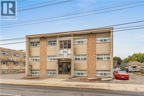 Three-story building featuring a concrete facade with stone veneer accents, multiple windows, and a prominent main entrance - 237 Mohawk Road E Unit# 16, Hamilton, ON - Outdoor