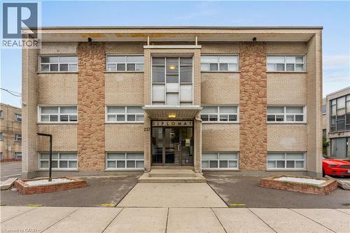 Brick facade building featuring three stories of windows with white frames - 237 Mohawk Road E Unit# 16, Hamilton, ON - Outdoor With Facade