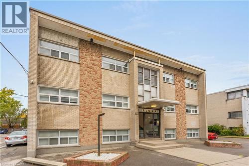 Three-story building with a light brick facade and stone-clad accents - 237 Mohawk Road E Unit# 16, Hamilton, ON - Outdoor