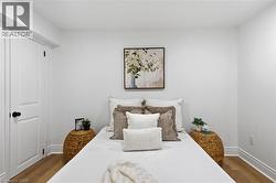 Bright interior room featuring white walls, wood-finish flooring, and white baseboards - 