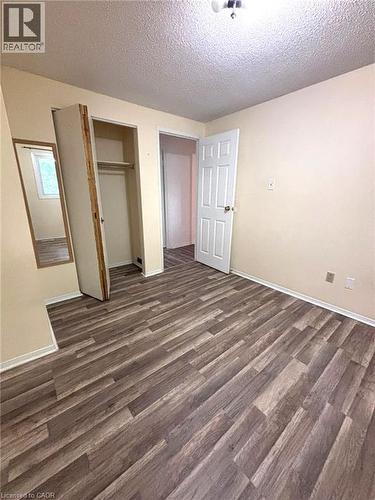 Interior room featuring wood-finish flooring, light neutral-toned walls, and a white six-panel door - 490 Third Street Unit# 40, London, ON - Indoor Photo Showing Other Room
