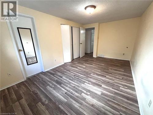 Spacious room featuring wood-finish flooring, light-toned walls, and a ceiling-mounted light fixture - 490 Third Street Unit# 40, London, ON - Indoor Photo Showing Other Room