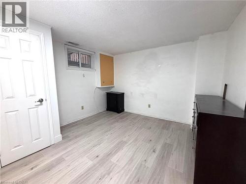 Spacious room featuring light wood-finish flooring, white painted walls, a standard white door, and a horizontal window - 490 Third Street Unit# 40, London, ON - Indoor Photo Showing Other Room
