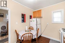 Compact kitchen featuring wood-finish flooring, white appliances, and warm neutral paint - 