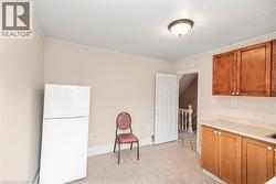 Kitchen area with light beige wall paint, tile flooring, and a flush mount ceiling light - 