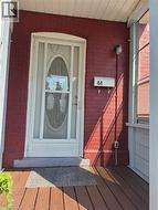 Red brick facade with a white storm door featuring an oval glass insert - 
