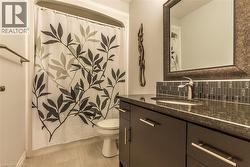 Vanity featuring a dark countertop, undermount sink, and brushed nickel faucet - 