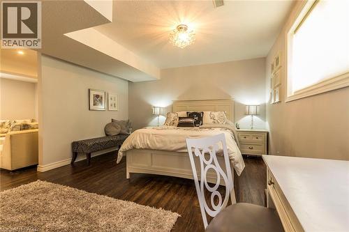 Spacious room featuring dark wood-finish flooring, light-toned walls, and a visible window with blinds - 44 Lemon Grass Street, Kitchener, ON - Indoor Photo Showing Bedroom