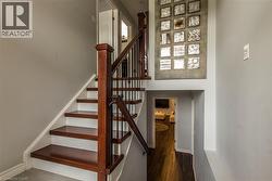 Staircase featuring dark wood-finish treads, white risers, and a dark wood newel post with black metal balusters - 