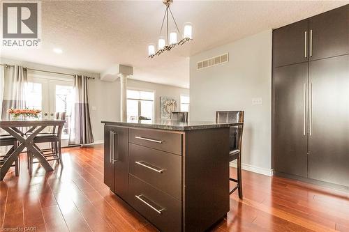 Kitchen island featuring a dark countertop, integrated storage, and bar seating - 44 Lemon Grass Street, Kitchener, ON - Indoor