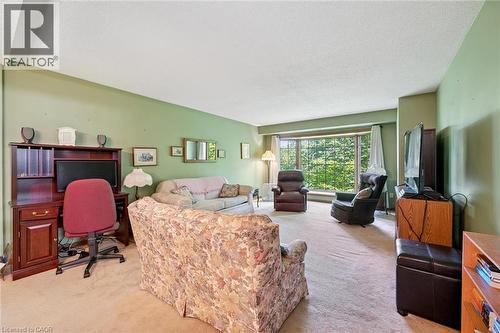 Spacious living area featuring a large bay window, light green wall finishes, and wall-to-wall carpeting - 4 Albert Street Unit# 105, Cambridge, ON - Indoor