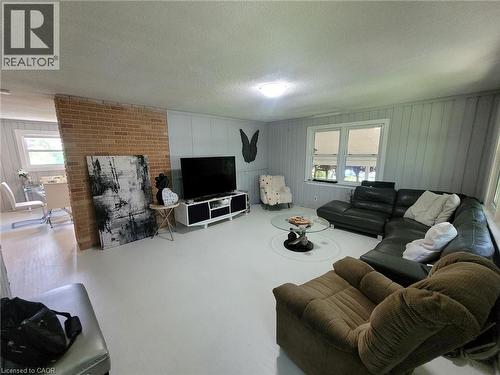 Spacious living area featuring light-toned flooring and vertical paneled walls - 879 West 5Th Street, Hamilton, ON - Indoor Photo Showing Living Room