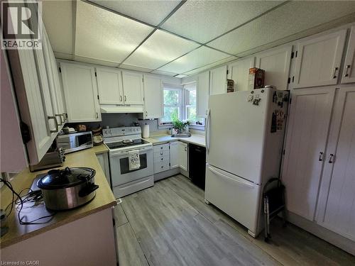 Kitchen featuring white cabinetry, light wood-finish countertops, stainless steel sink, and wood-finish flooring - 879 West 5Th Street, Hamilton, ON - Indoor Photo Showing Kitchen