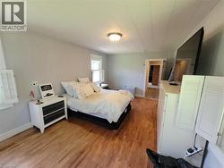 Spacious room featuring wood-finish flooring, light grey walls, and a recessed ceiling light fixture - 