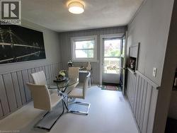 Dining area featuring painted board and batten wainscoting and light-colored flooring - 