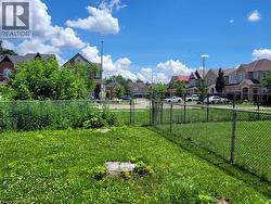 Expansive green space featuring a chain-link fence - 