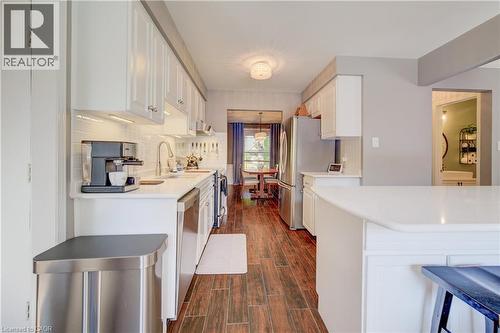 Kitchen featuring wood-finish flooring, white cabinetry, a light-colored countertop, stainless steel appliances, and a subway tile backsplash - 41 Mcniven Road, Ancaster, ON - Indoor Photo Showing Kitchen With Upgraded Kitchen